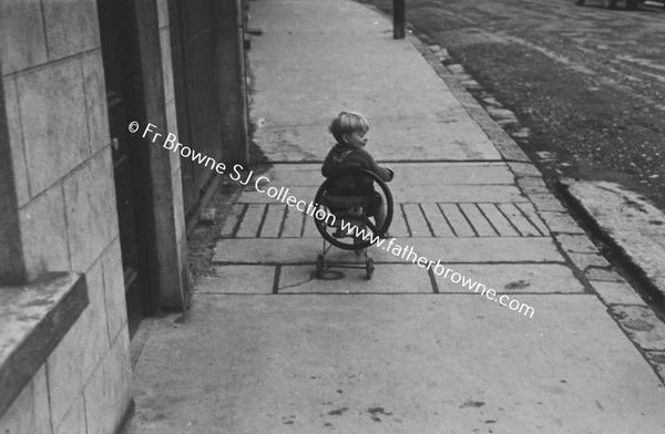 CHILD ON TRICYCLE IN STREET